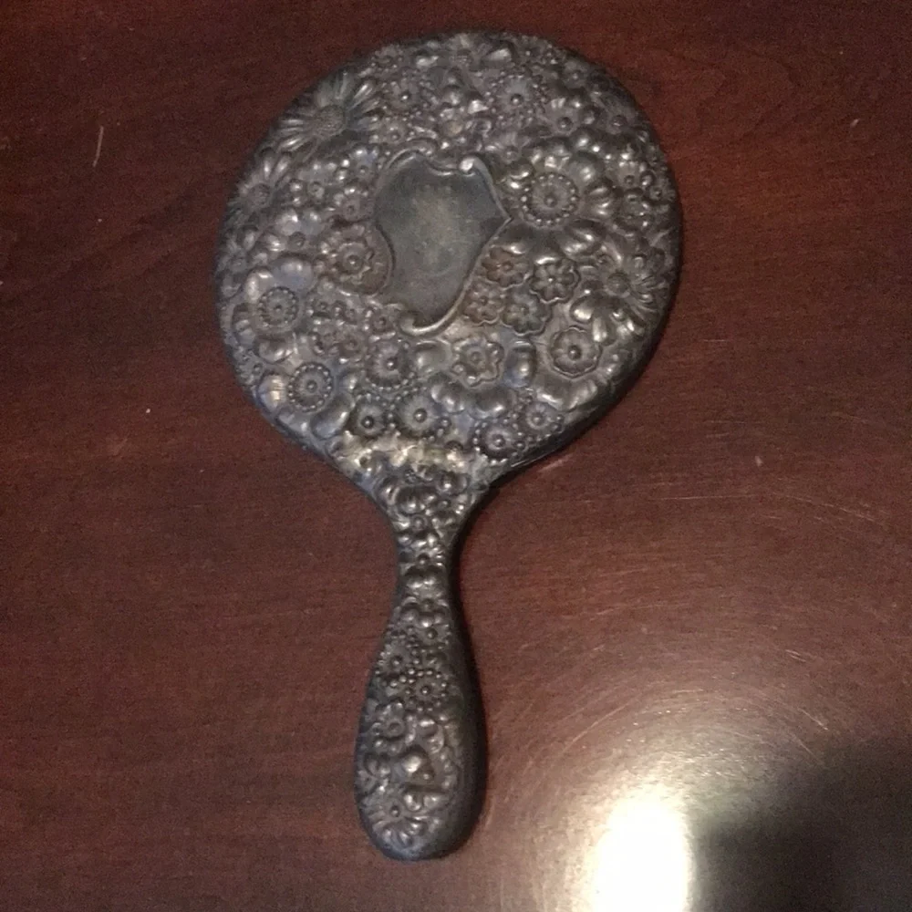 Vintage silver hand held mirror with raised flowers
